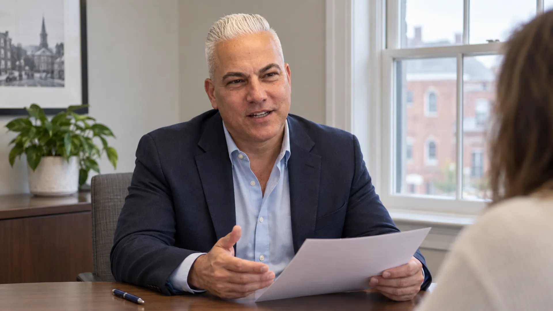 Dan Balkun explaining purchase-closing documents to a buyer at a conference table